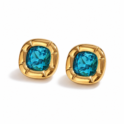 Paloma Cushion Stone Earrings – blue cushion-cut stones in sculptural gold settings on white