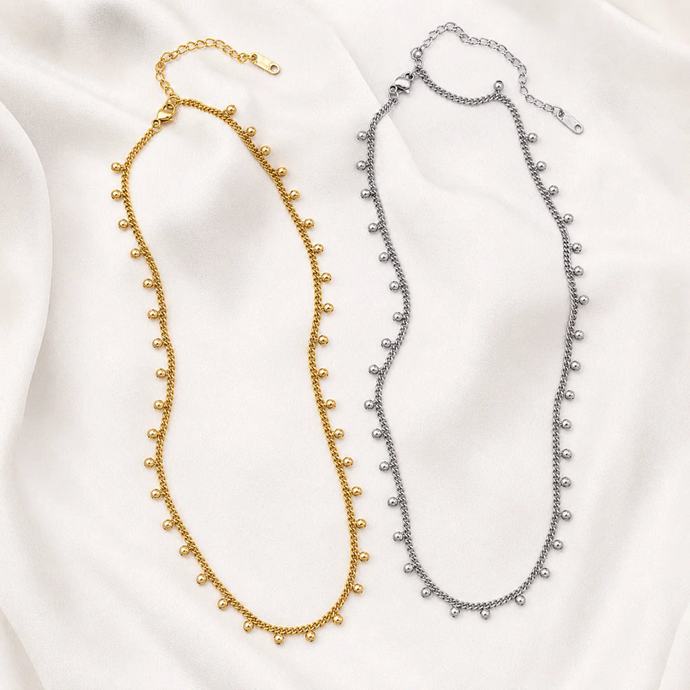 Celia Necklace – gold and silver ball charm necklaces on fabric