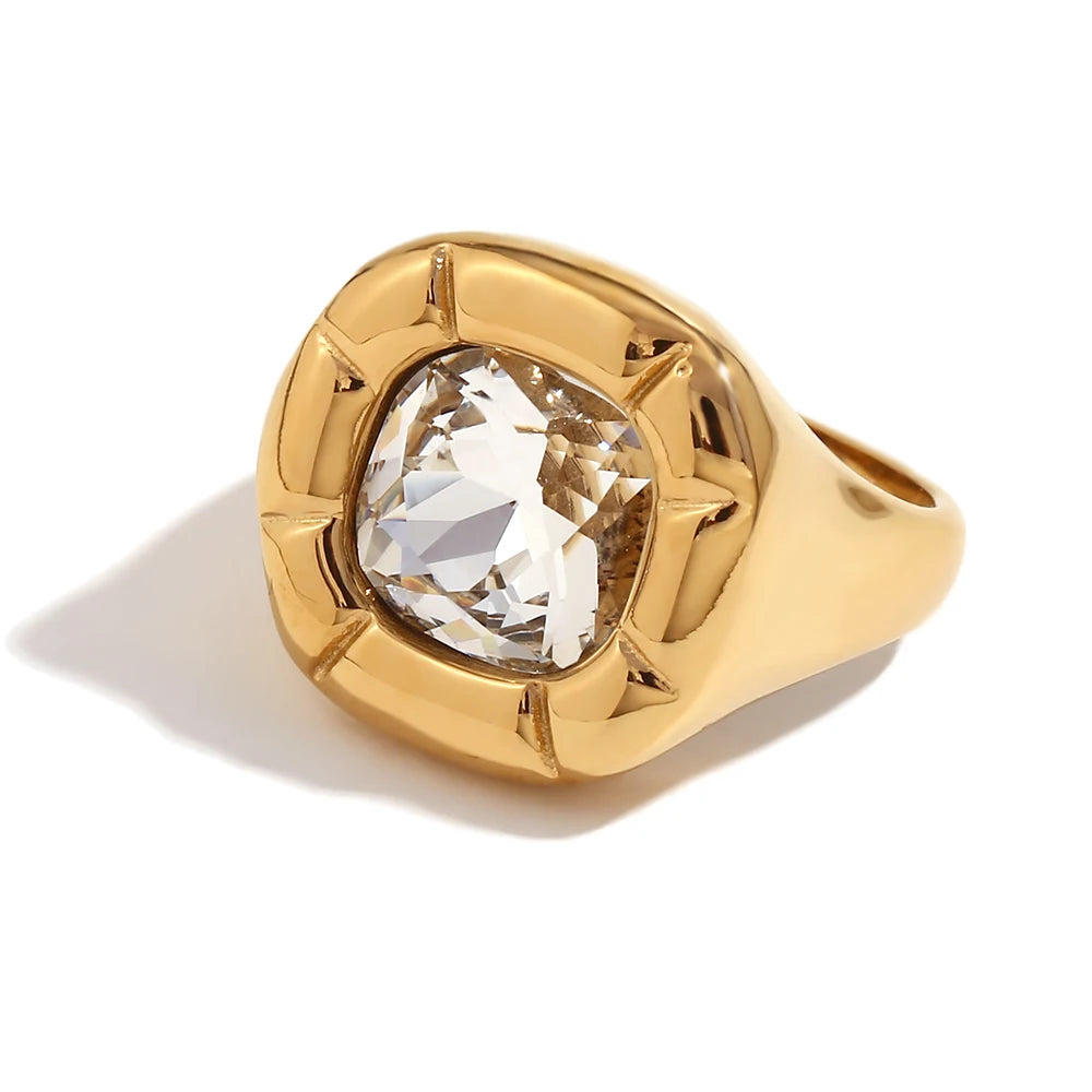 Paloma Cushion Stone Ring – clear cushion-cut stone in a sculptural gold ring on white